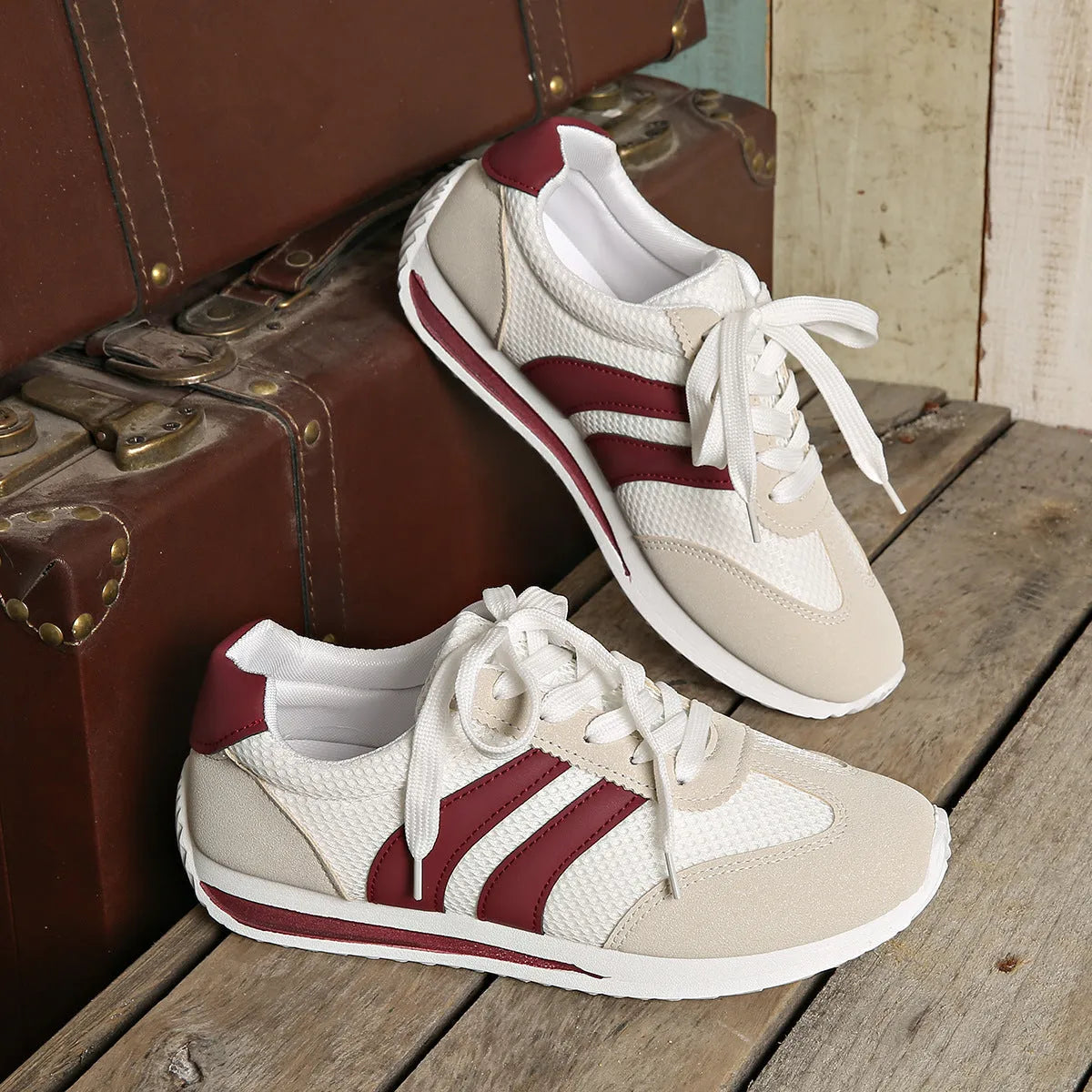 Wine red Cortez Retro sneaker with mesh upper, cross strap, and flat rubber sole.