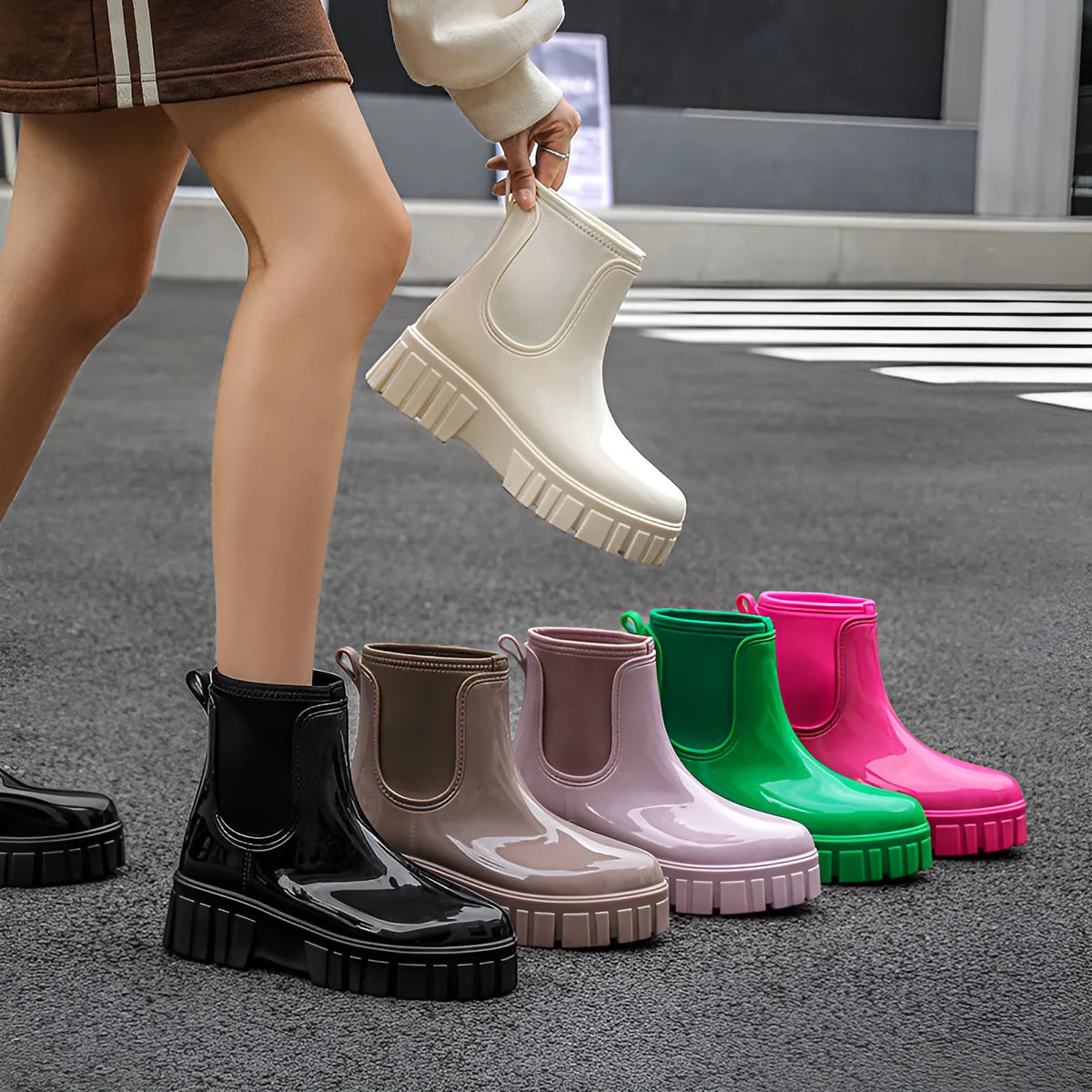 Creamy-white low tube PVC rain boot with non-slip sole on a wet surface.