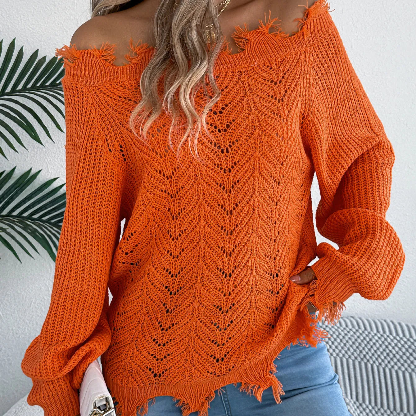 White women's pullover sweater with cut-off-the-shoulder neckline and hollow-out patterned long sleeves.