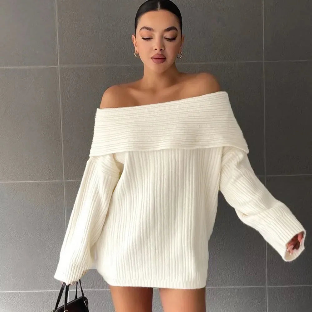 A woman wearing a loose, long-sleeved acrylic pullover sweater in a neutral colour.