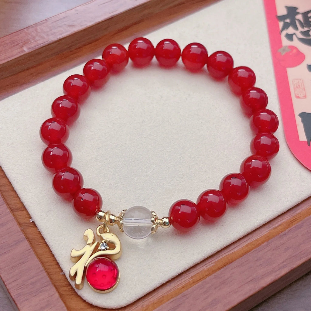 A red agate bracelet for women with a manual crafted dragon design in Chinese style.