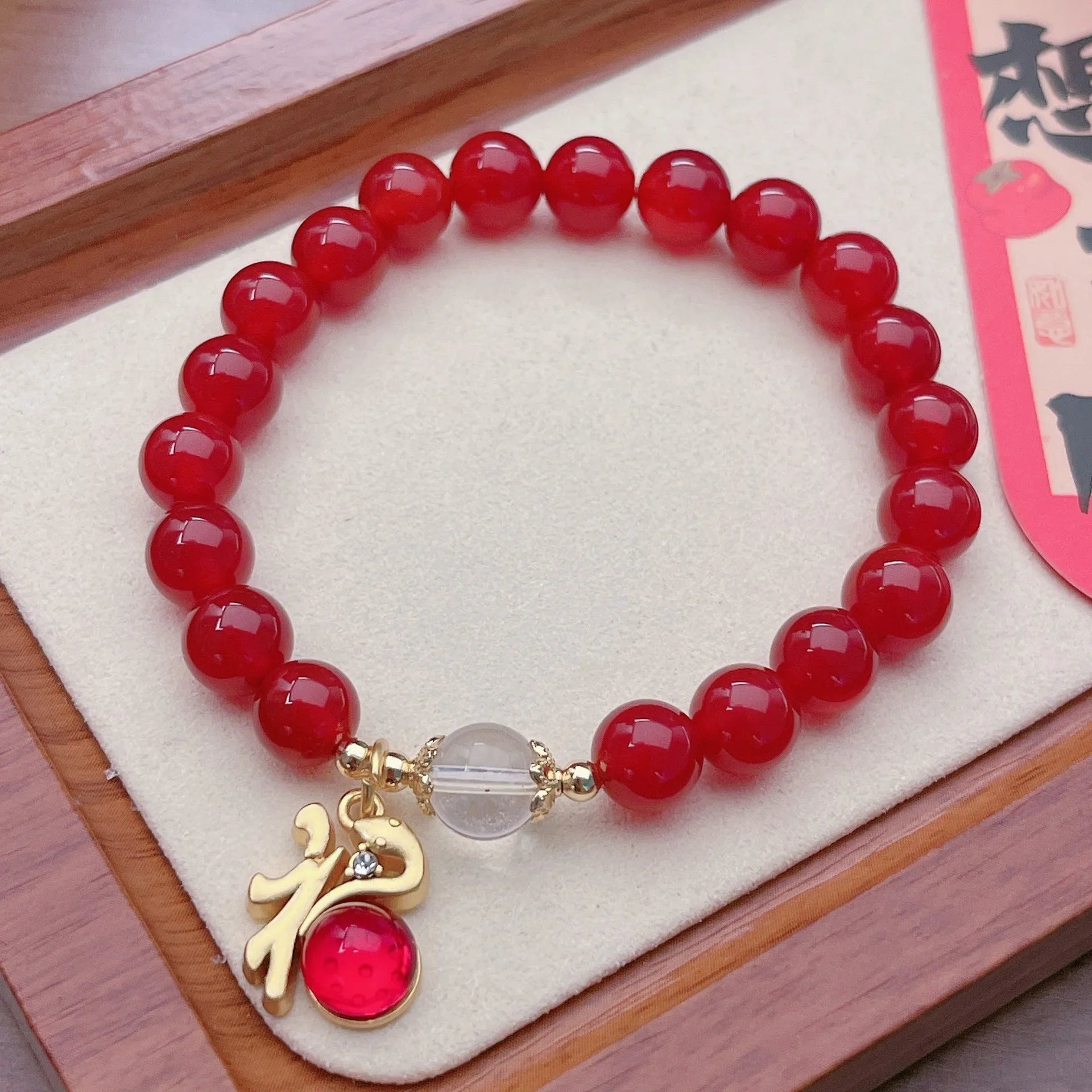 A red agate bracelet for women with a manual crafted dragon design in Chinese style.