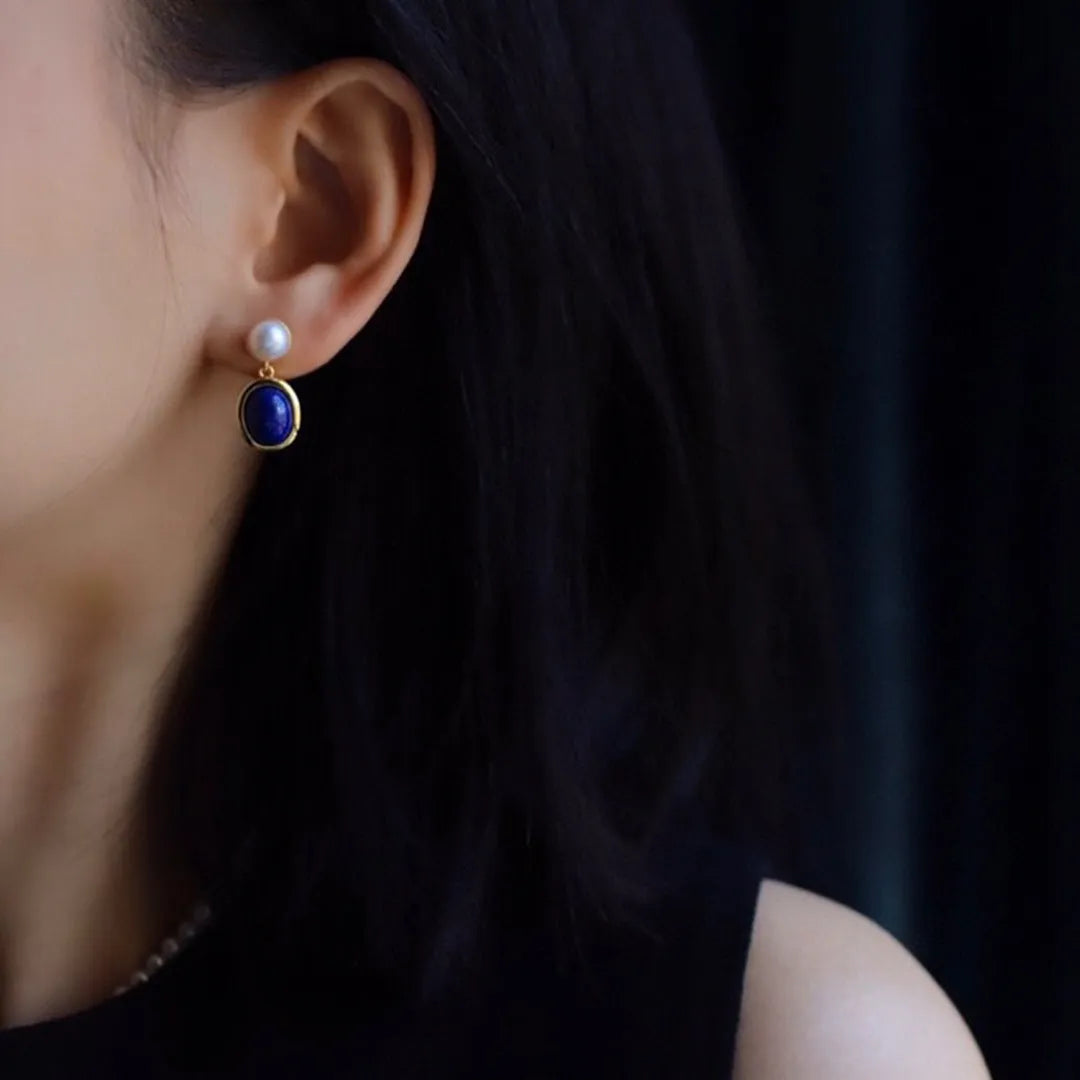 A pair of simple sterling silver stud earrings with a lapis lazuli pearl colour and auspicious patterns.