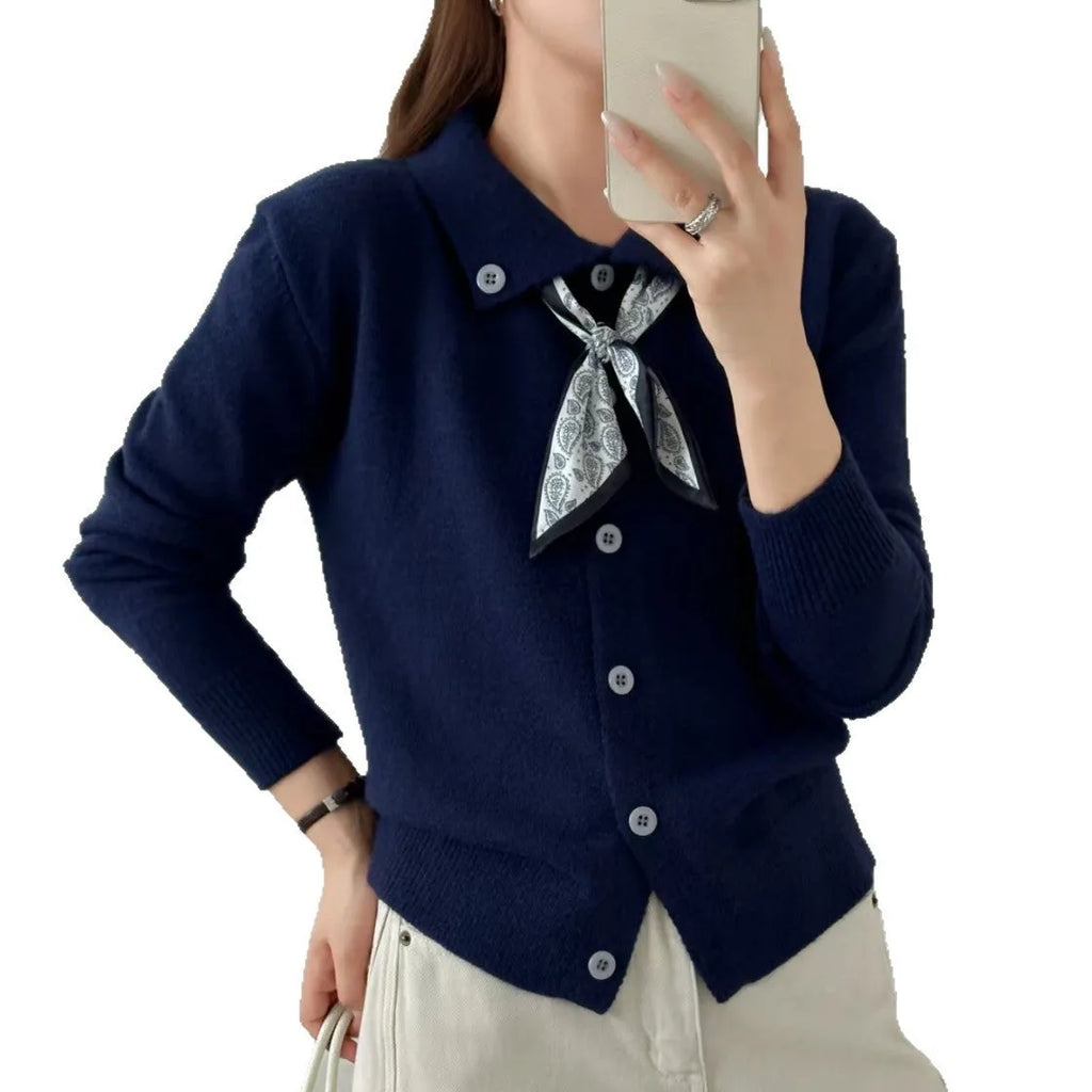 Milky white acrylic cardigan sweater with lapel collar and scarf trim detail, long sleeves.