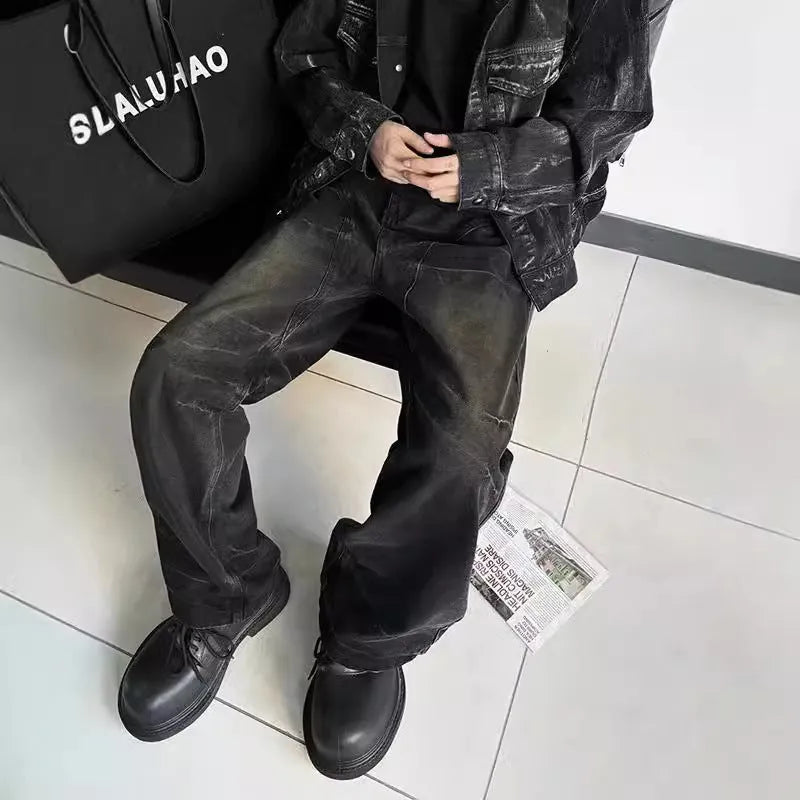 Washed black straight denim trousers with deconstructed dirty mud texture and zipper fly