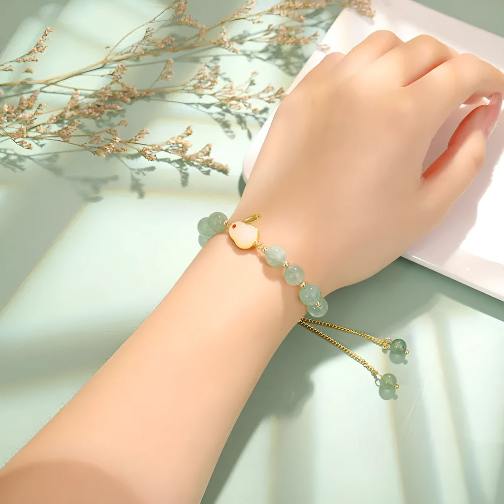 Rabbit charm bracelet with green natural stone beads and gold accents on adjustable chain