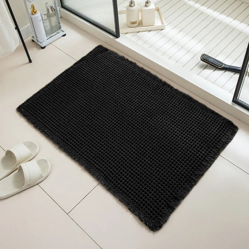 A square, checkered-pattern bathroom carpet in a choice of colours on a tiled floor.