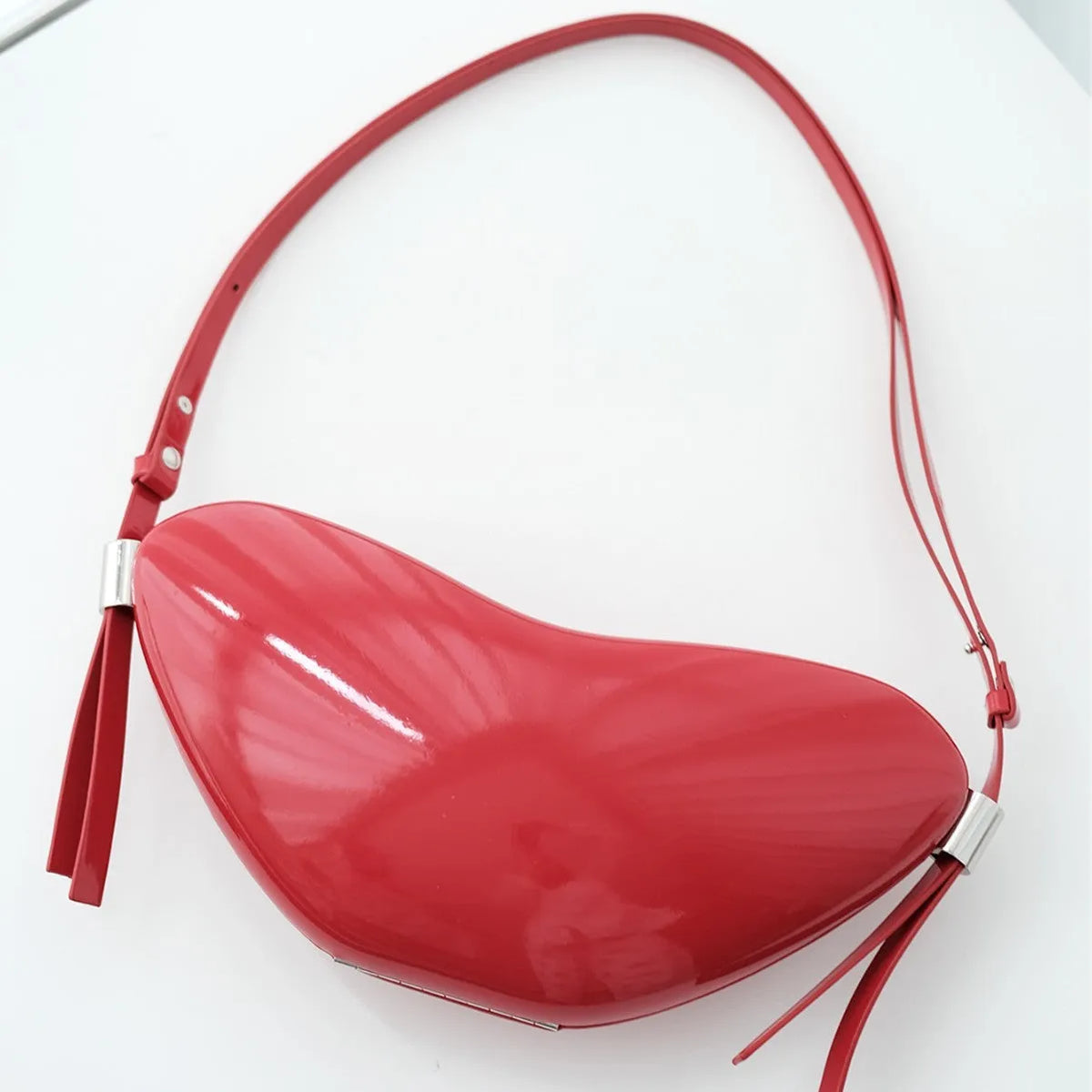 Red heart shaped crossbody bag in solid PU synthetic leather with single shoulder strap and sandwich pocket