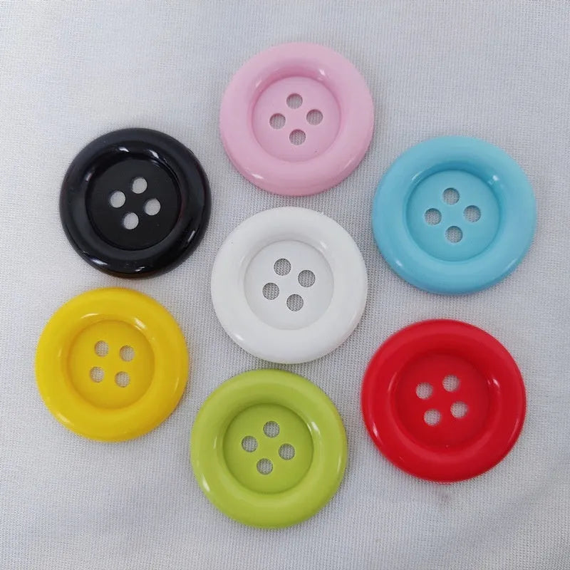 Assortment of oversized round plastic buttons in multiple colours with four holes.