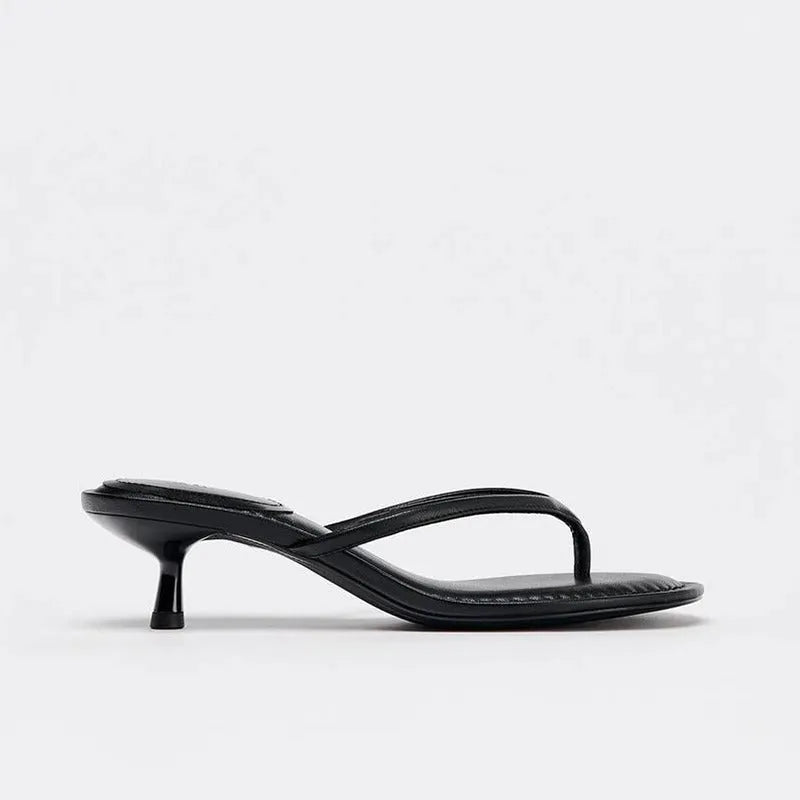 Black women's mid-heel sandals with a round toe and flip-toe strap on a white background
