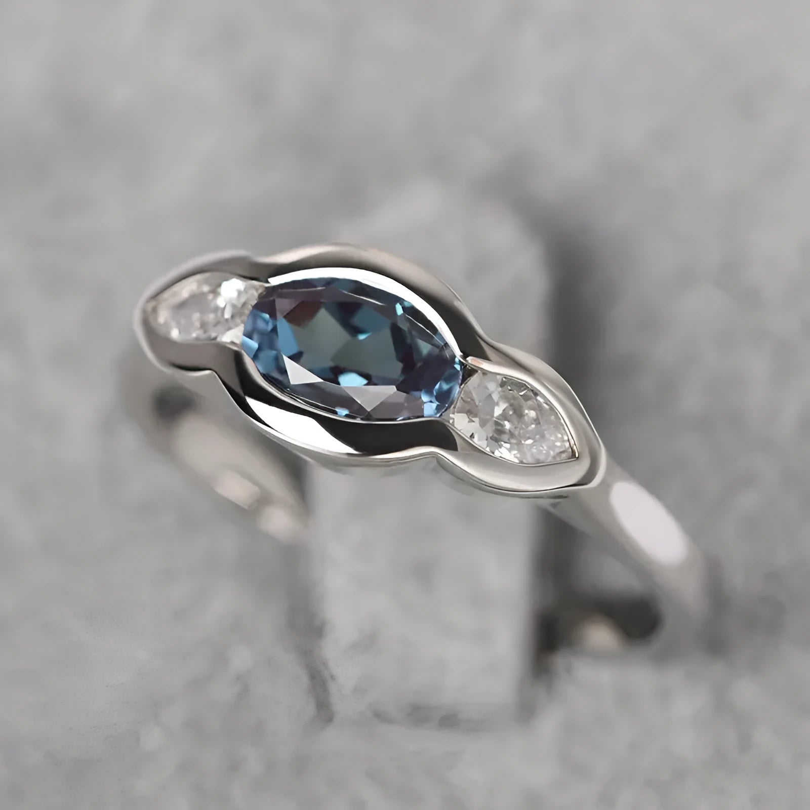 Women's geometric ellipse ring with inlaid zircon stone in white gold colour, shown on a hand.