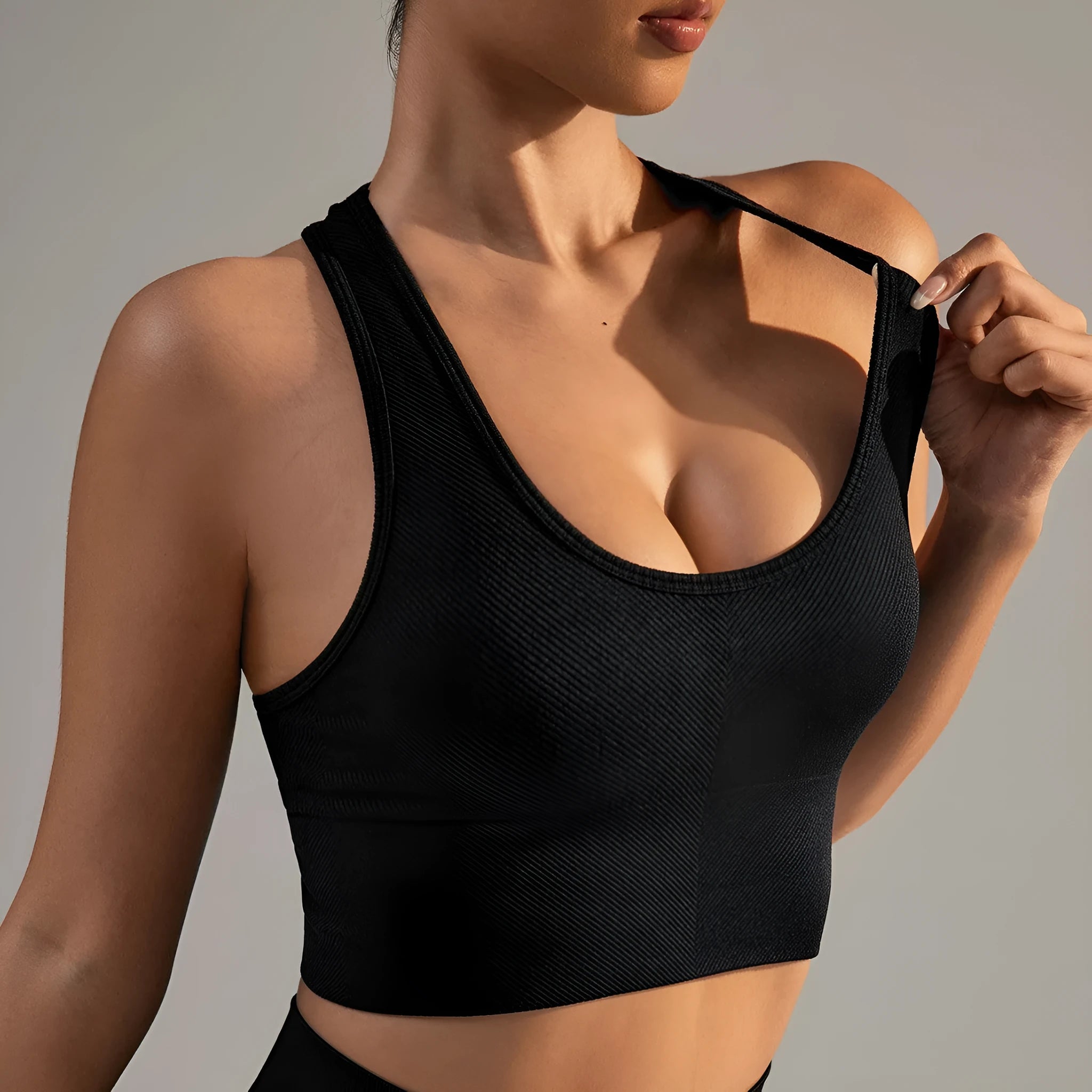 Black women's sports bra with cross back design and full cup support for athletic wear.