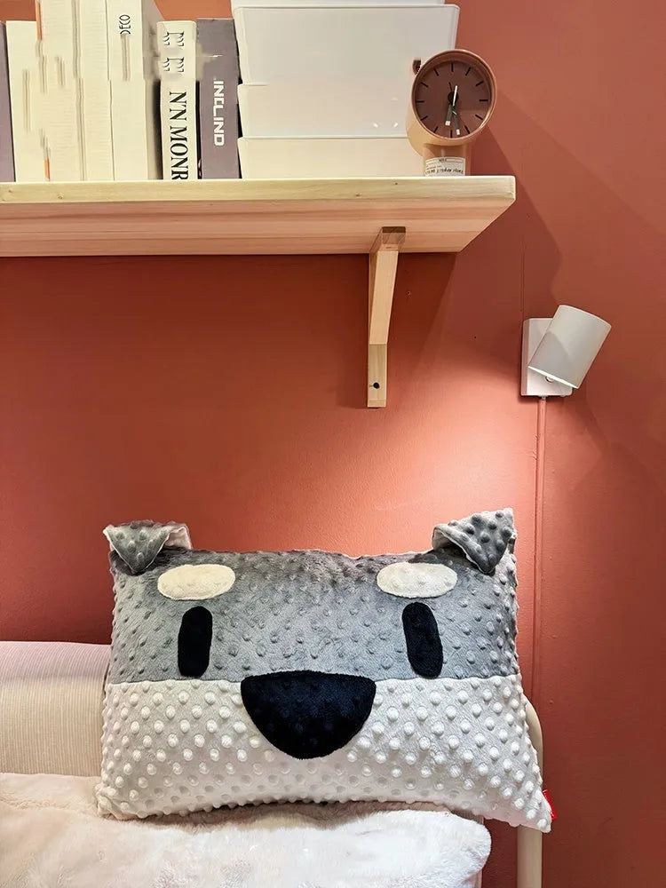 Grey and white West Highland terrier puppy-shaped dog pillow on a sofa.