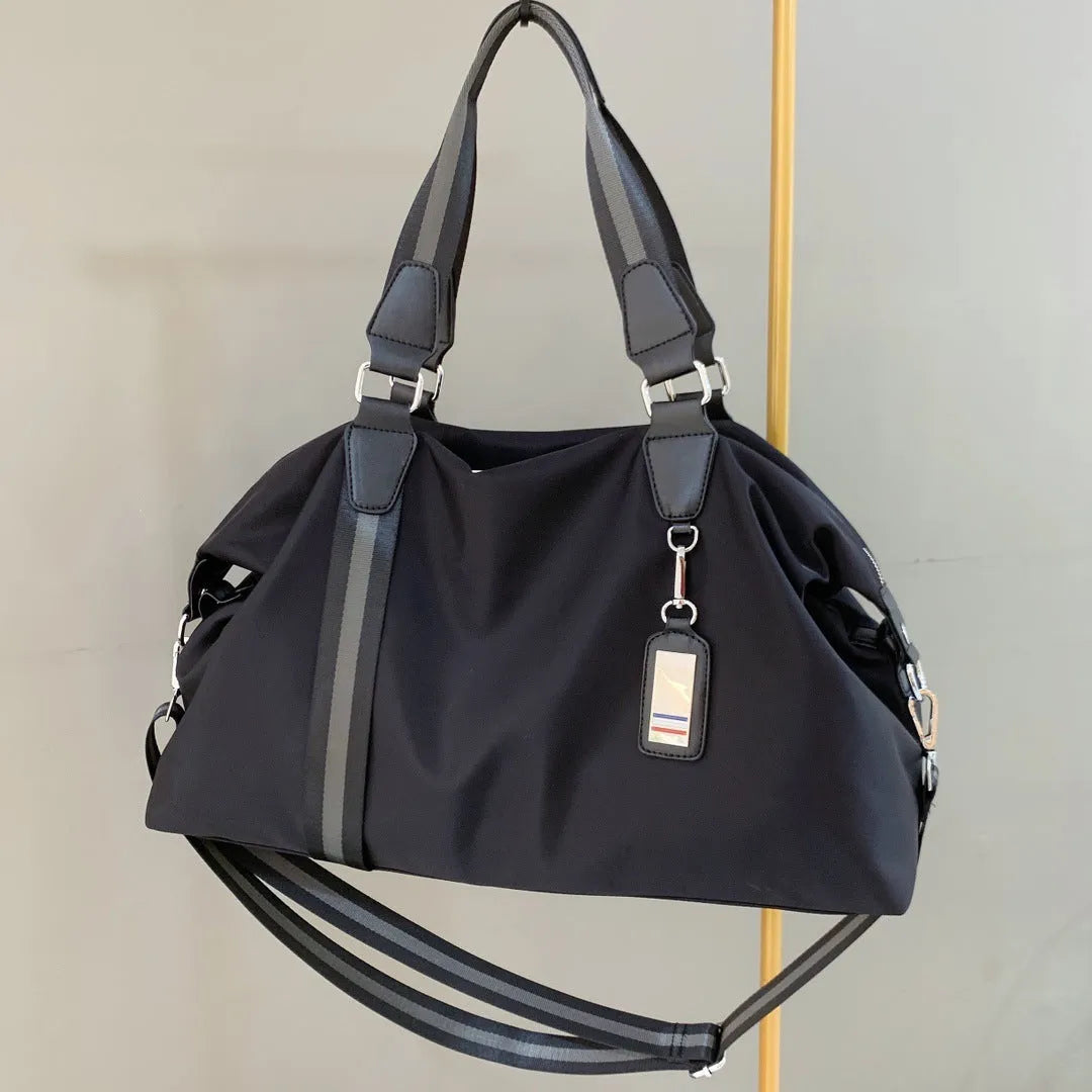 Black Gold Oxford cloth travel bag with zipper closure and three shoulder strap points on plain background