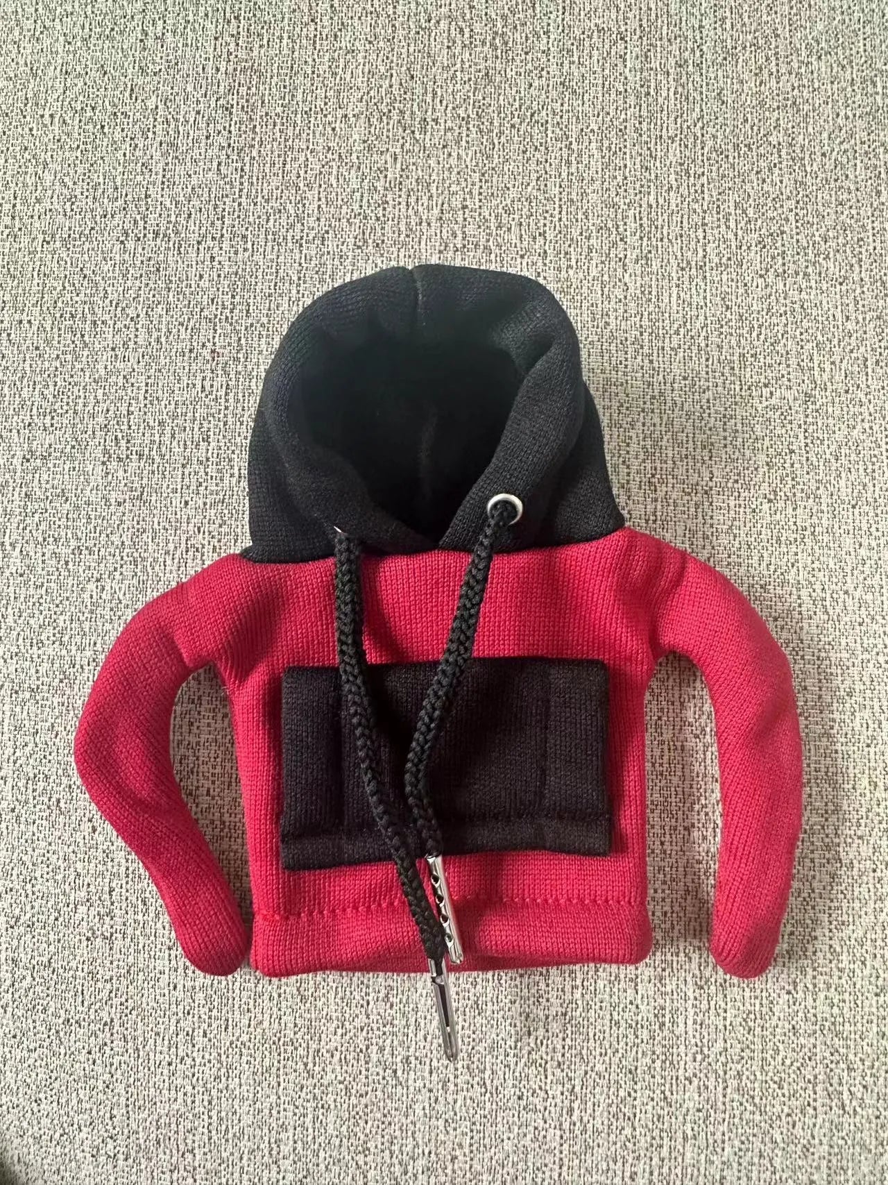Polyester knit hooded cover stretched over a car manual gear lever in a red and white colour combination.