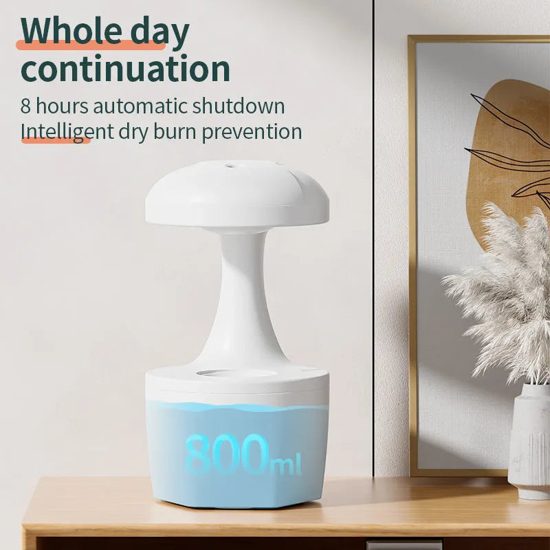 White portable 800ml anti gravity USB cool mist aromatherapy humidifier on a bedside table with water droplet effect visible