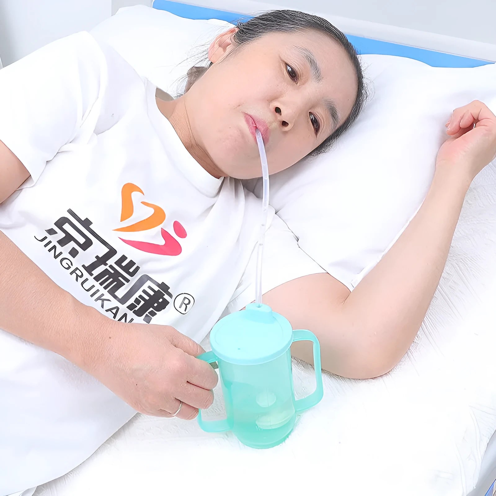 Bedside drinking cup with slanted mouth, handle, and optional wrist splint for adult care