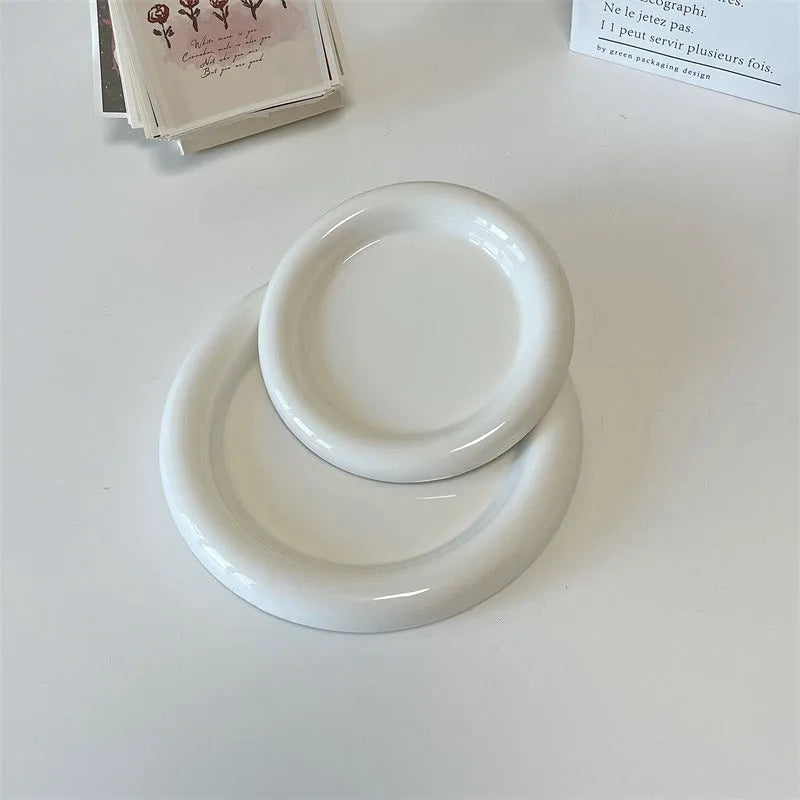 White round porcelain plant plate with a bear doodle design, shown under a small succulent pot.