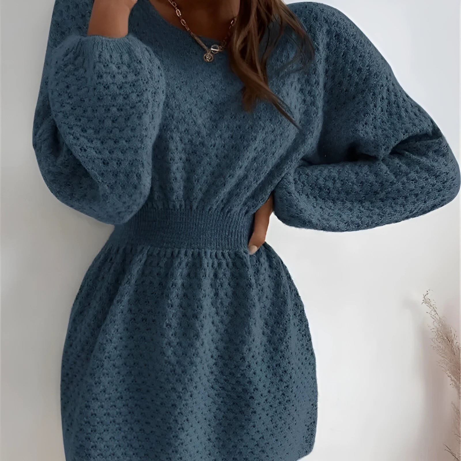 Blue women's knitted dress with hand-crocheted flowers, fitted waist, and round neckline