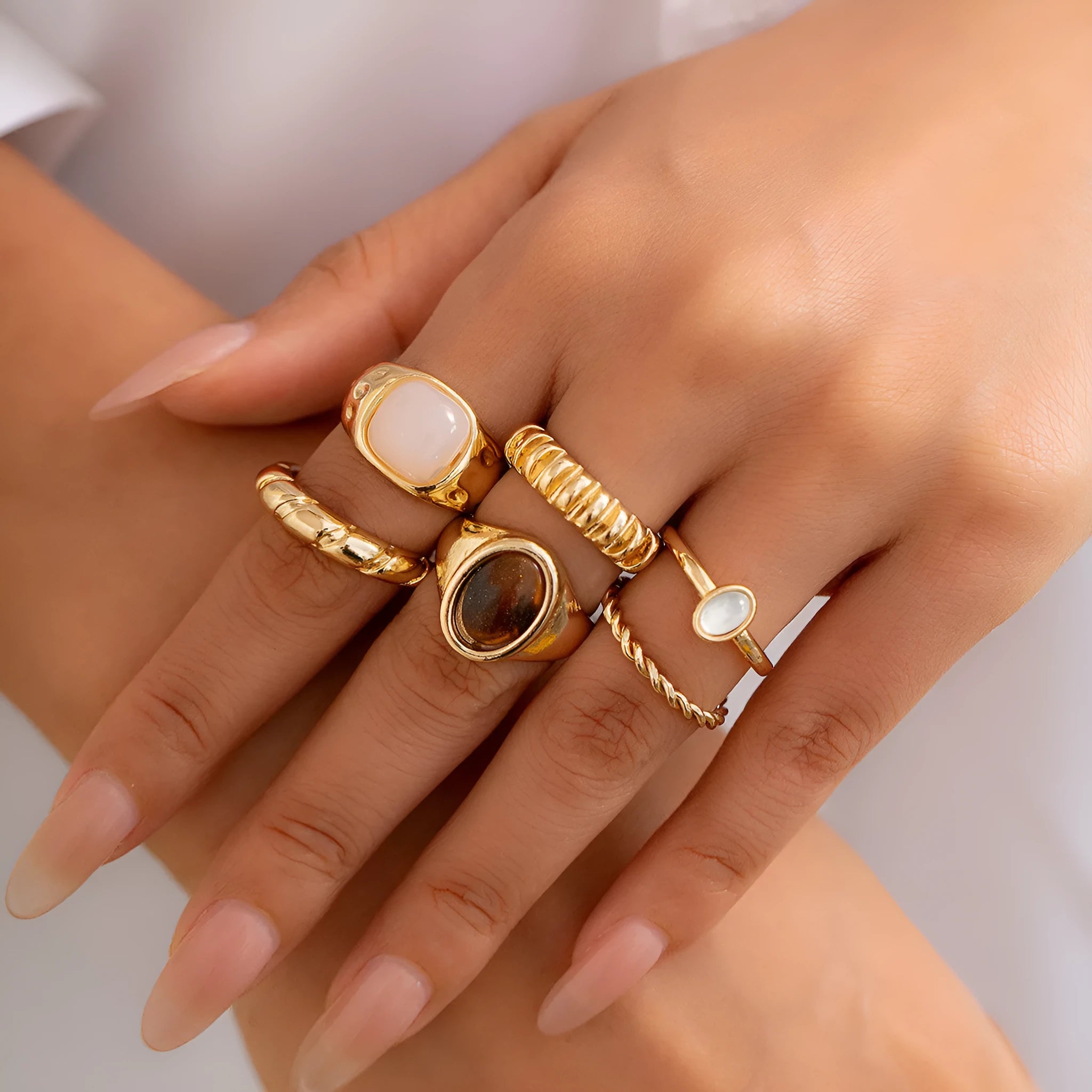 Six light gold geometric alloy rings arranged as a set showing geometric shapes and round elements