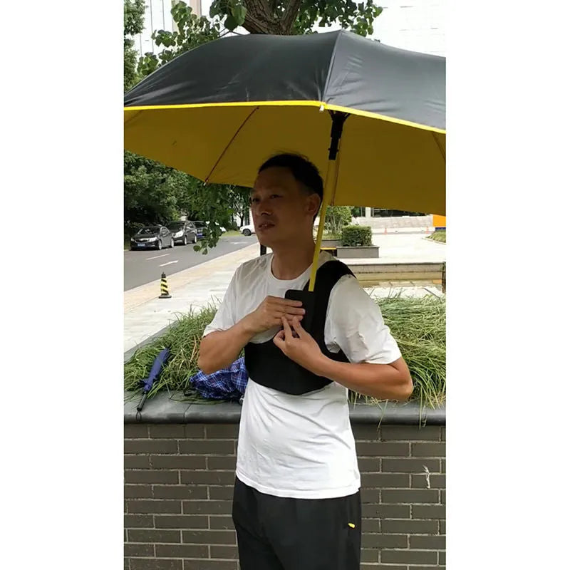 Black portable umbrella holder with a fixed shoulder strap, shown holding a manual folding umbrella.