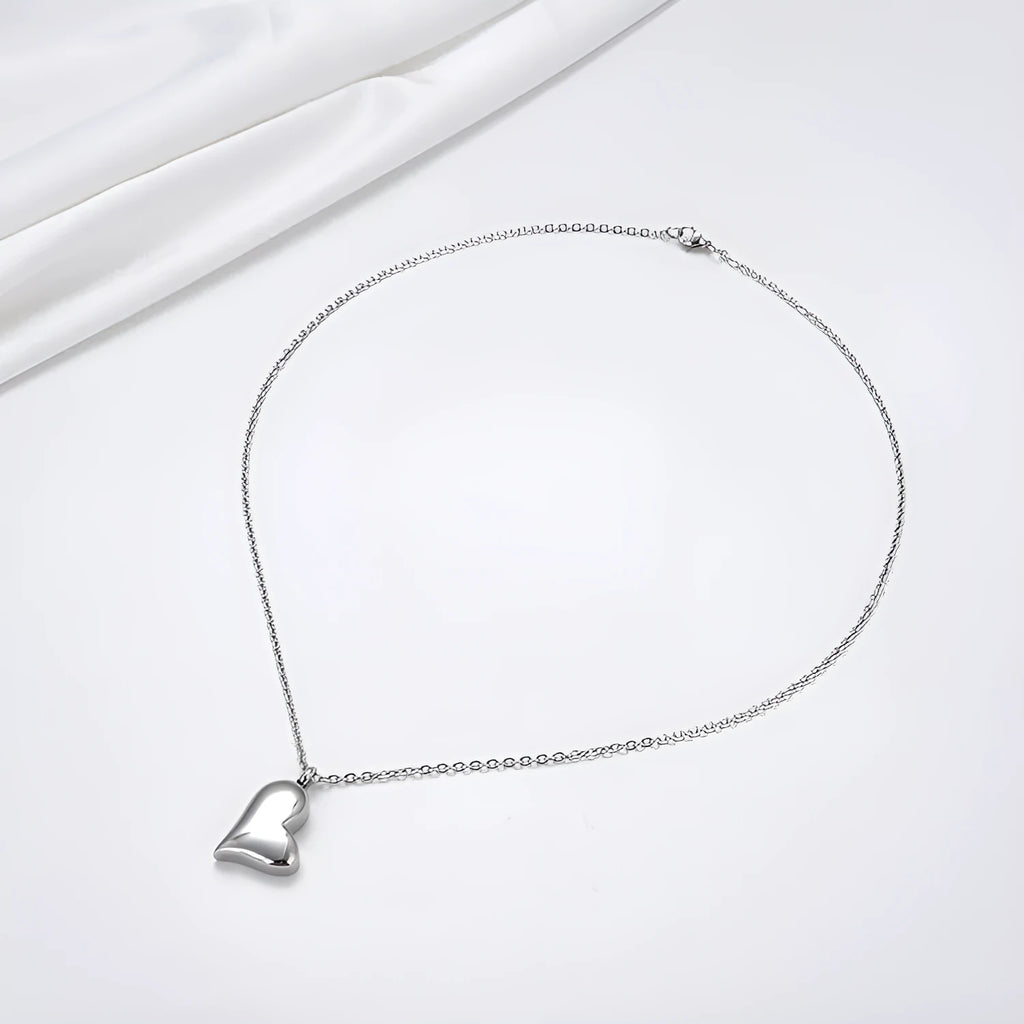 Silver curved peach heart pendant necklace on a stainless steel chain with extension.