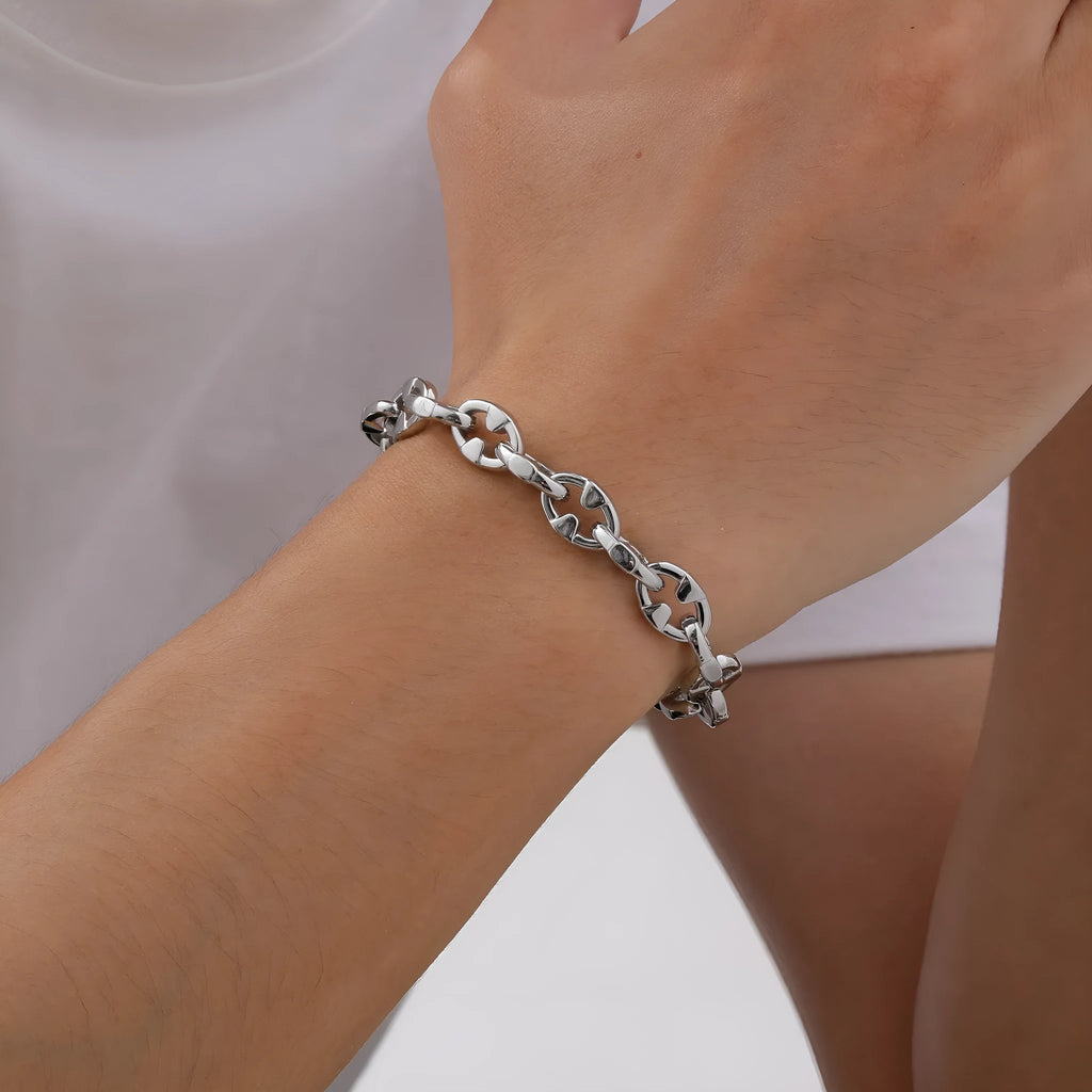 A thick, geometric stainless steel chain bracelet shown on a wrist, highlighting its handmade links and steel colour.