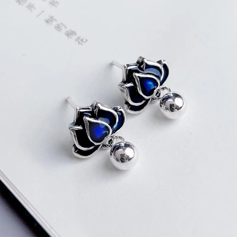 Blue lotus flower alloy ear studs with a retro seedpod tassel, shown from the front.