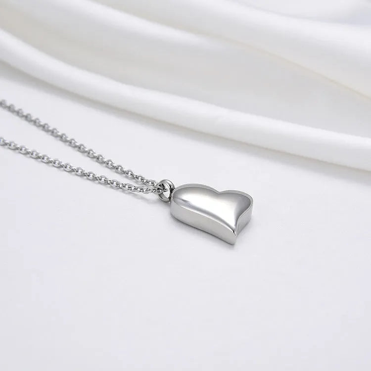 Silver curved peach heart pendant necklace on a stainless steel chain with extension.
