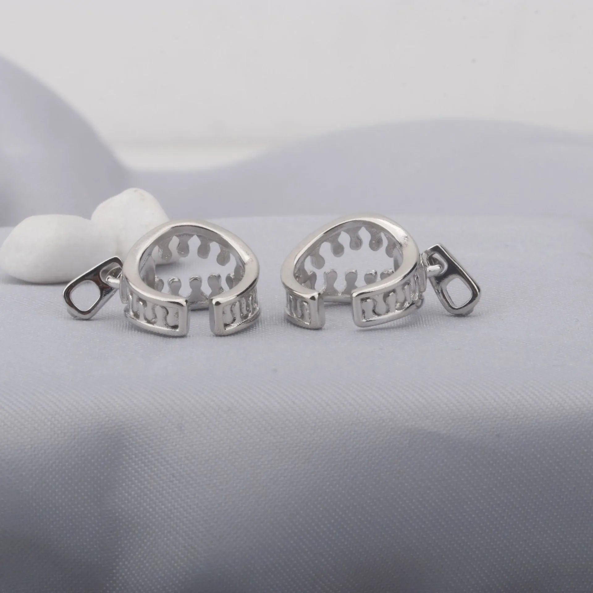 A pair of geometric-shaped copper ear clips with a zipper design detail, colour ES862.