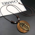 Ethnic style wooden leaf pendant necklace on an adjustable wax-line chain.