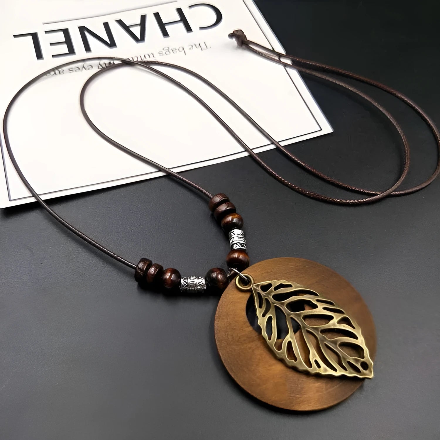 Ethnic style wooden leaf pendant necklace on an adjustable wax-line chain.