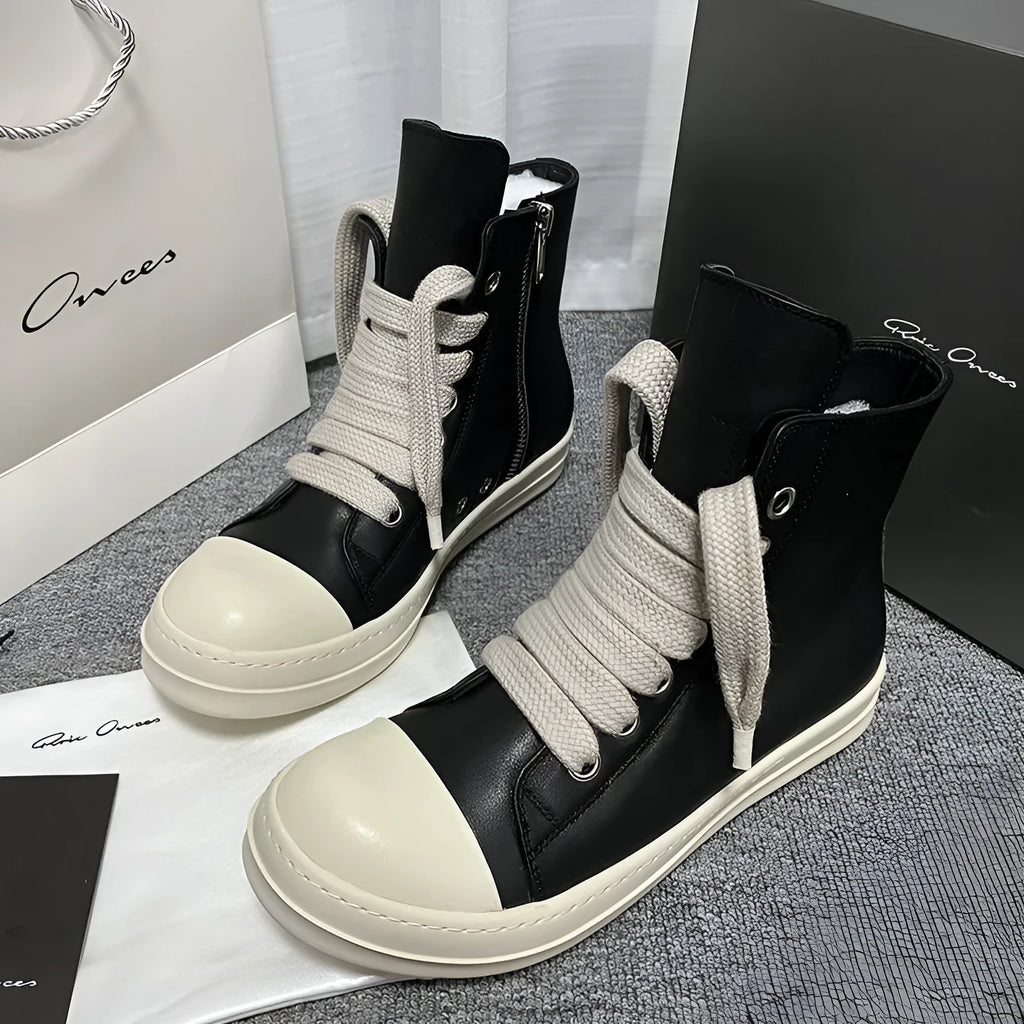 Black high-top leather sneakers with a side zipper and round toe on a rubber sole.