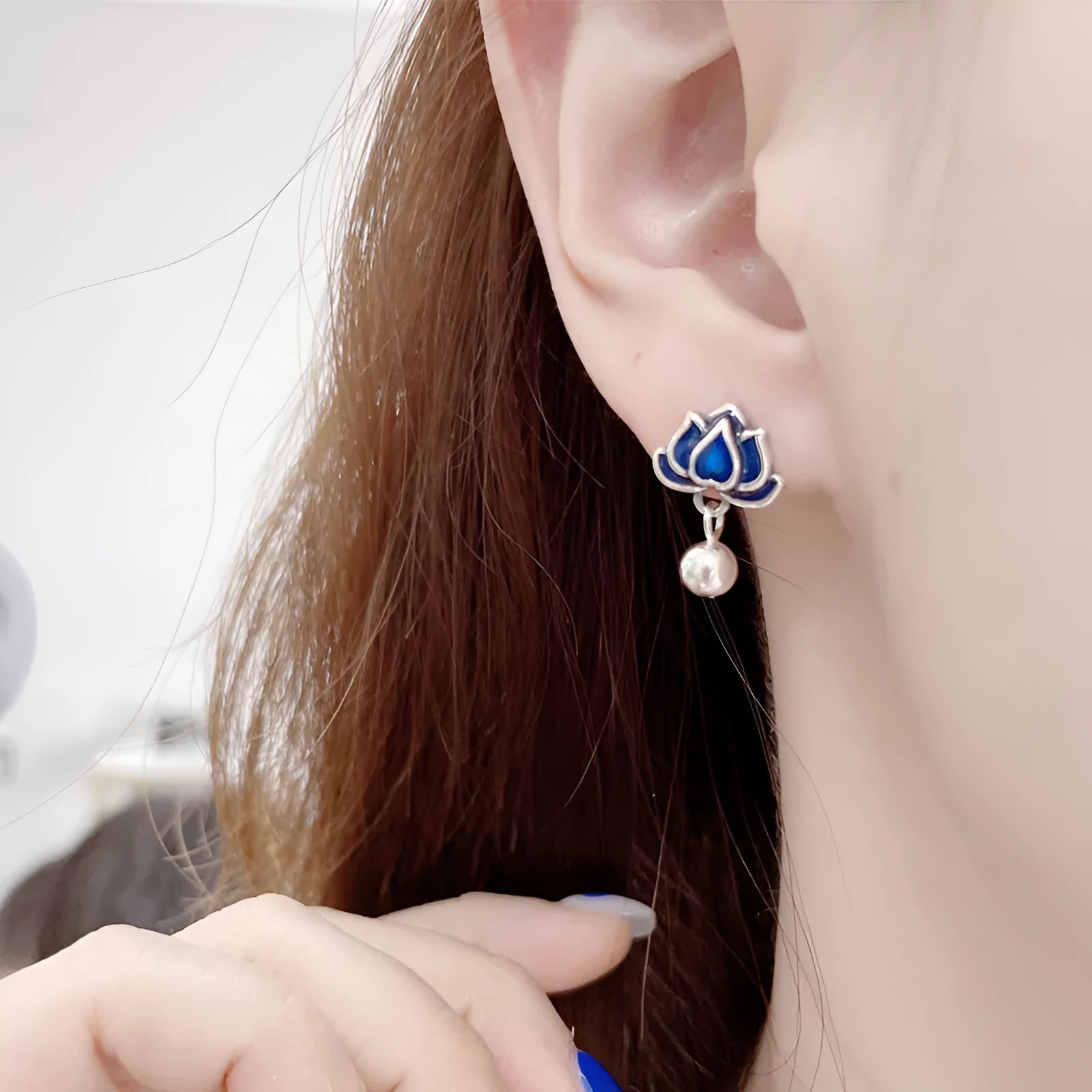 Blue lotus flower alloy ear studs with a retro seedpod tassel, shown from the front.