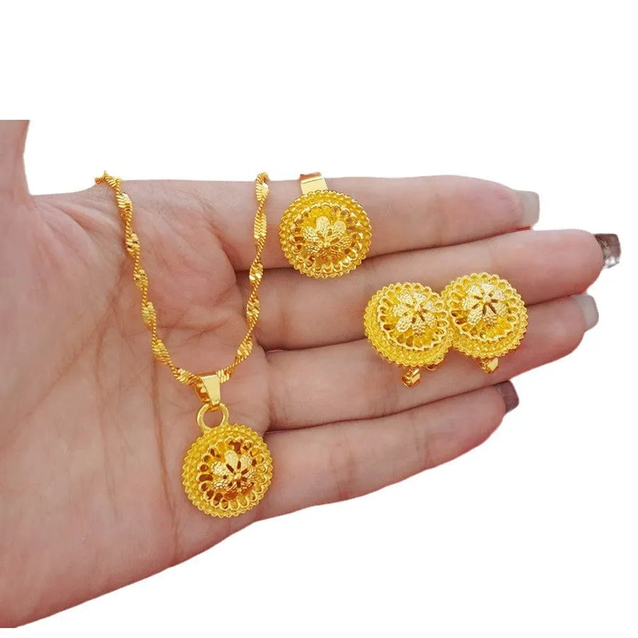 Gold-plated three-piece jewellery set with floral design pendant, matching earrings and ring on water wave chain