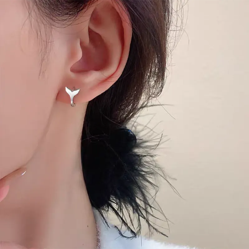 A pair of simple fishtail design earrings with a metallic electroplated finish in either white gold or yellow gold colour.