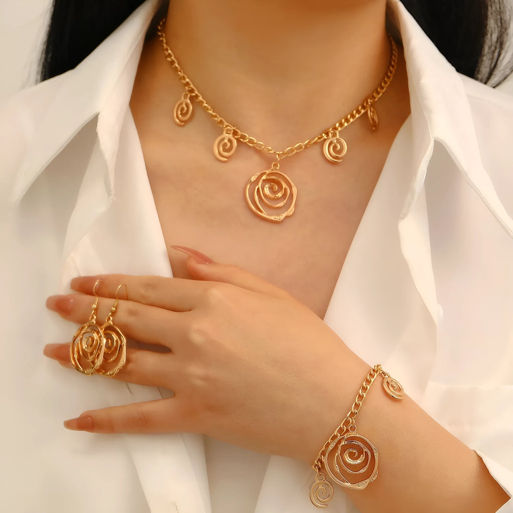 Gold tone spiral donut necklace, bracelet, and earrings set on a white background