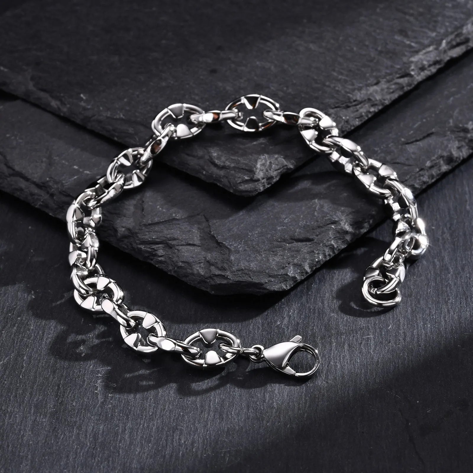A thick, geometric stainless steel chain bracelet shown on a wrist, highlighting its handmade links and steel colour.