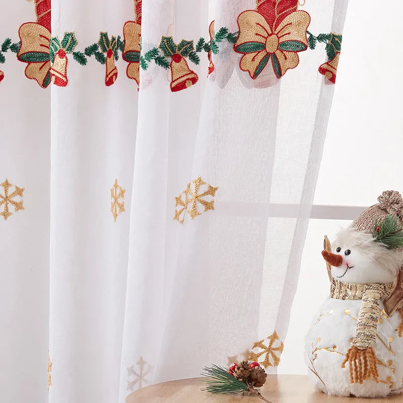 A pair of American-style Christmas curtains with white embroidered snowflakes on a red background.