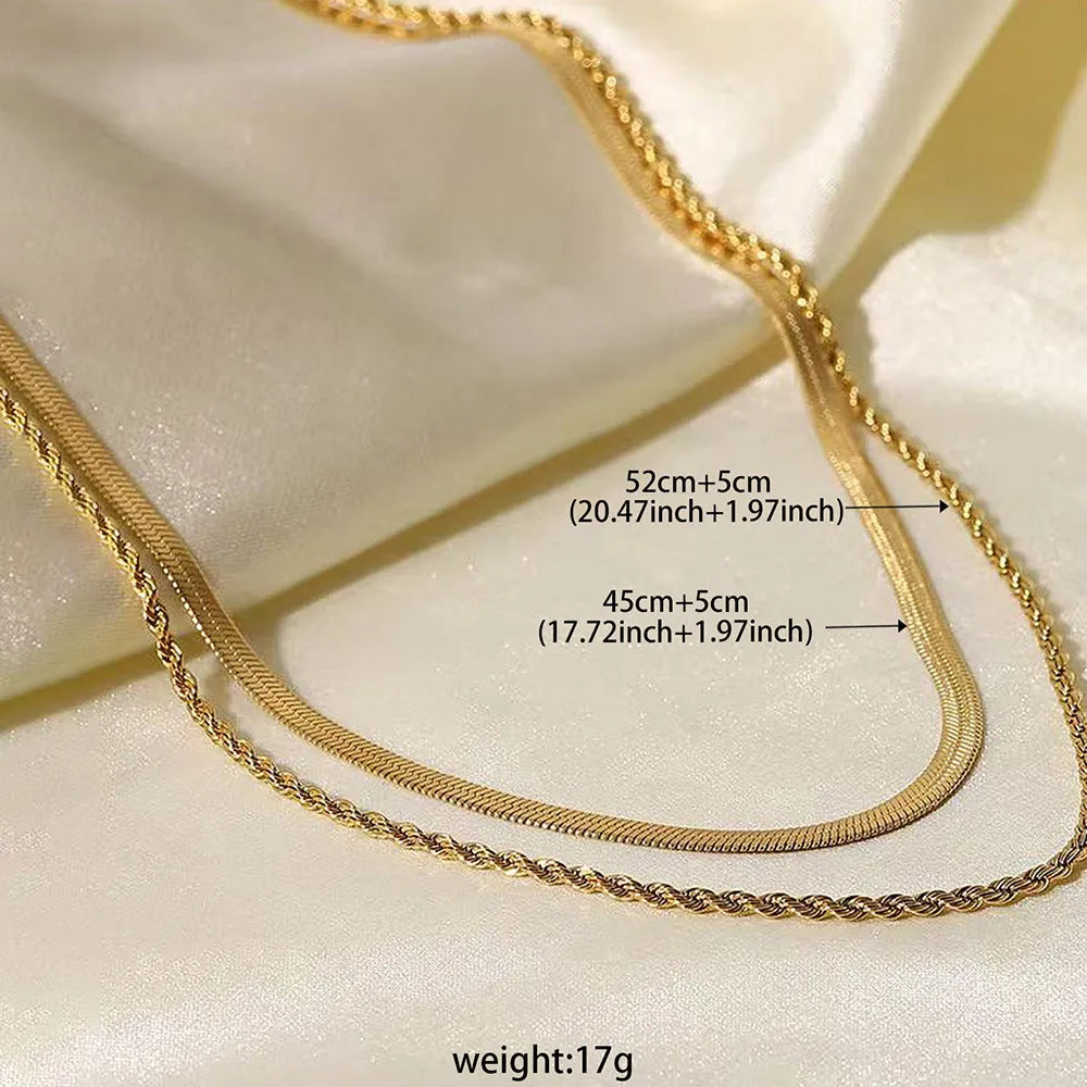 Close-up of a silver geometric double-layer twist pendant on a textured snake bones chain necklace.