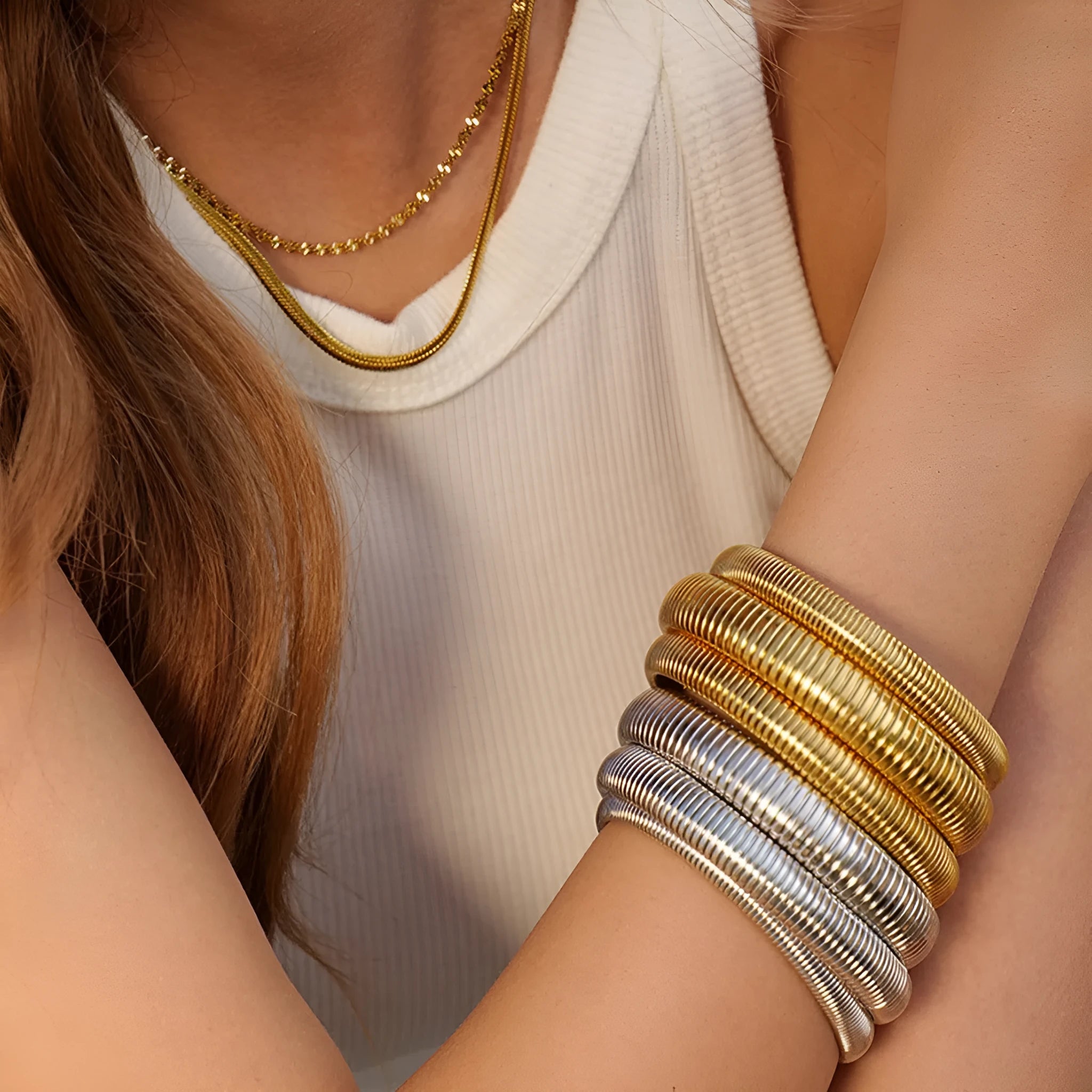 Women's gold titanium steel bracelet with exaggerated vertical stripe ring elastic pattern, showing width options.
