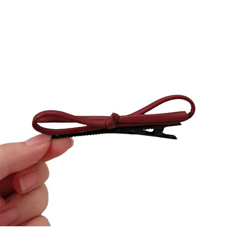 Wine red leather bow barrette hair clip for women showing manual crafted detail