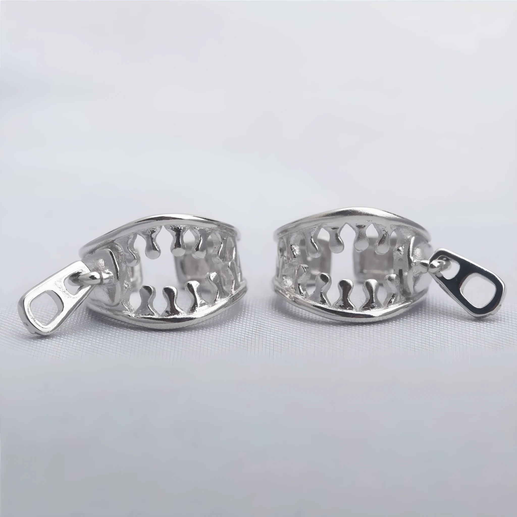 A pair of geometric-shaped copper ear clips with a zipper design detail, colour ES862.