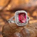 Women's copper square ring with red finish and a central rhinestone, showing geometric design.
