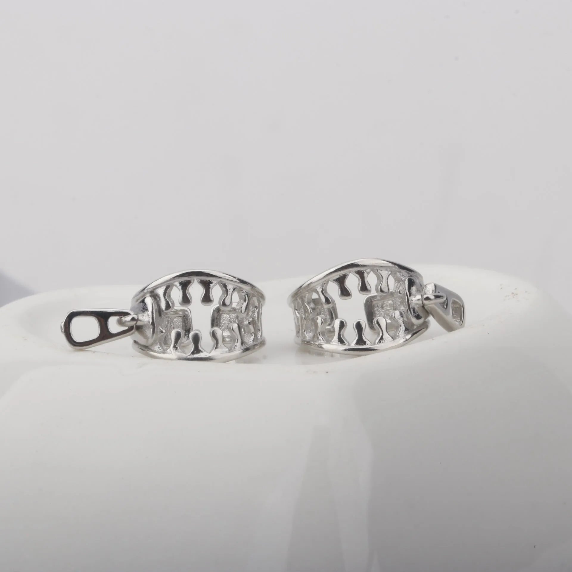 A pair of geometric-shaped copper ear clips with a zipper design detail, colour ES862.