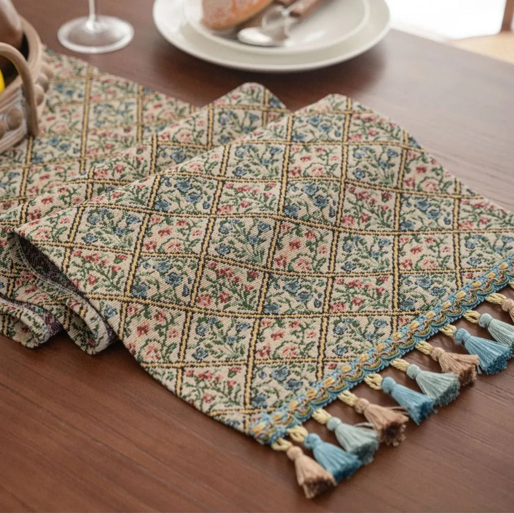 Rhyme Nordic jacquard table runner with tassel trim in a striped pattern, laid flat on a wooden table.