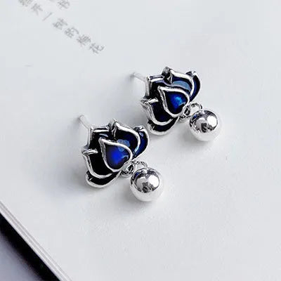 Blue lotus flower alloy ear studs with a retro seedpod tassel, shown from the front.