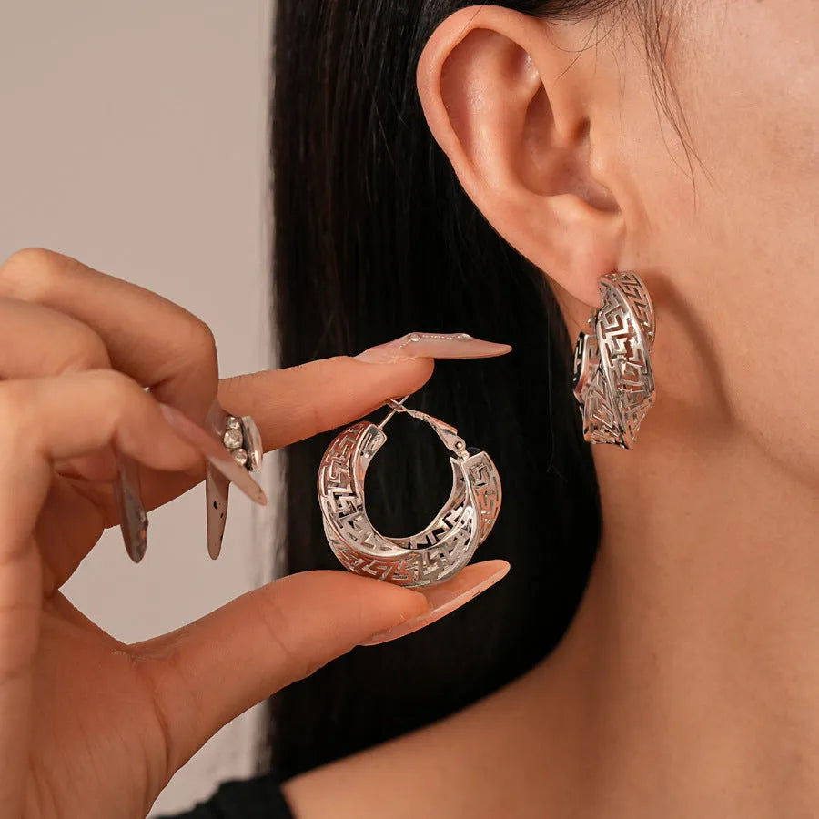 Geometric round hollow stud earrings for women with a twisted design in gold or silver finish.