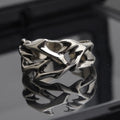Copper thorn flower geometric ring with adjustable opening on a flat surface.