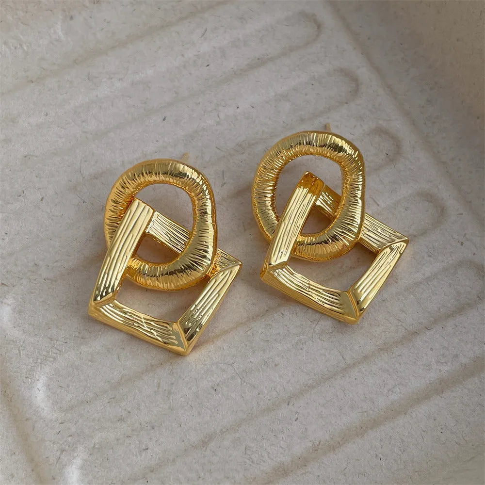 Gold and silver geometric circle pendant earrings with a 3.4cm drop length on a white background.